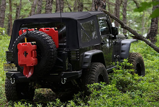 a jeep wrangler having off-road gas can parked in a jungle 