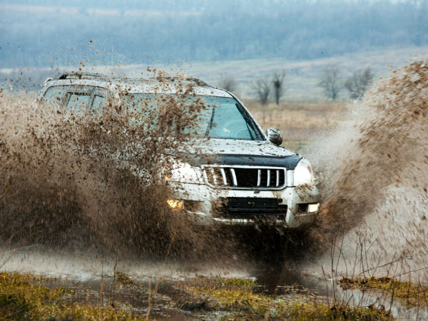 A jeep is passing away through deep water