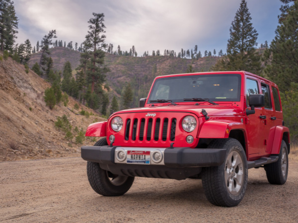 red jeep having rancho shocks parked in the middle of a dirt road