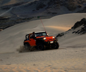 red jeep wrangler on white covered field searching for radio frequency with cb antenna