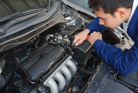 Auto mechanic checking car engine