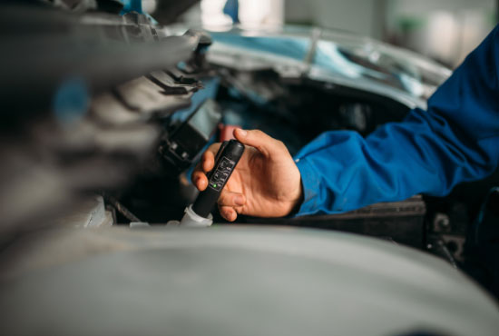 Male Technician Checks Brake Fluid Level in Car
