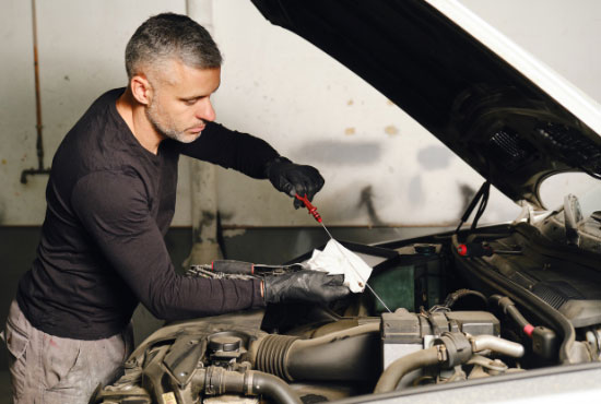 Worker Changing the Car Oil