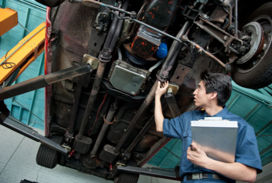 mechanic checking drive shaft